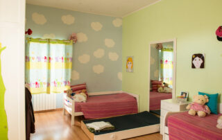 Quarto de criança com duas camas e peluches