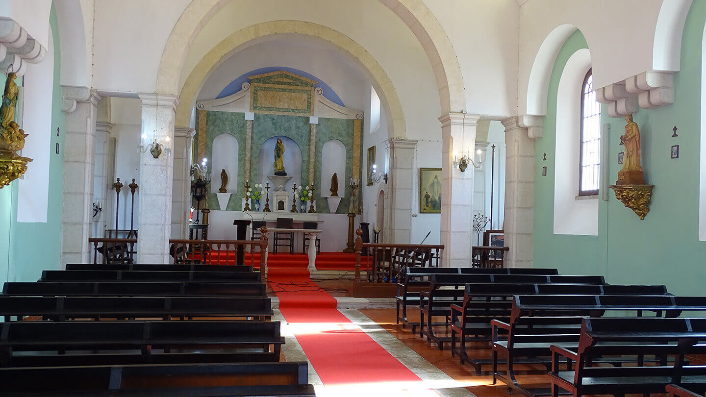 Altar e bancos no interior da capela