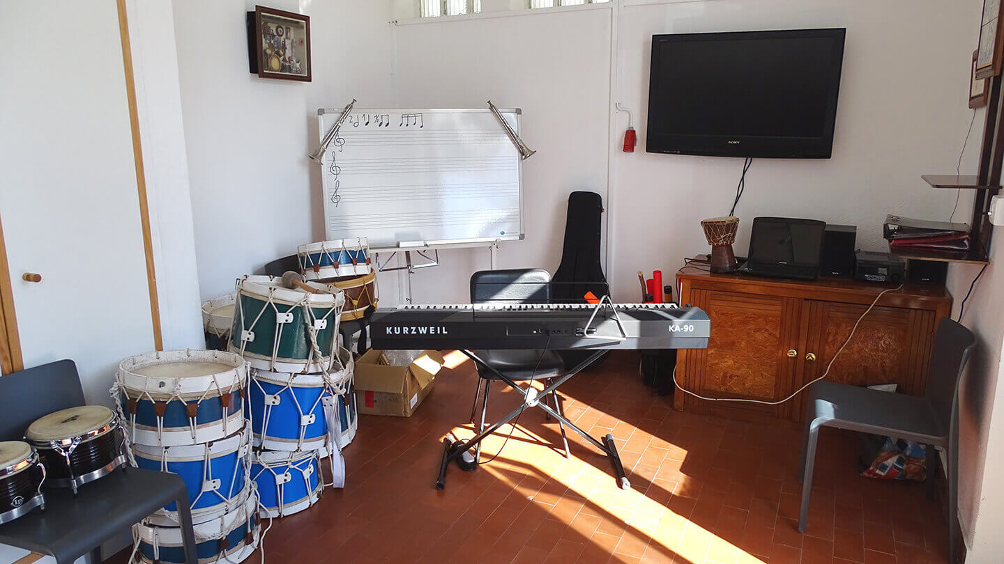 Interior da Sala de música com vários bombos e um orgão