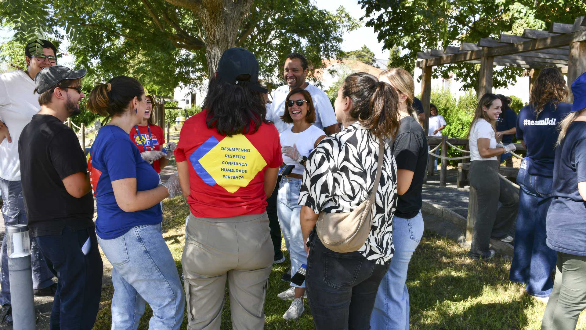colaboradores do Lidl e formandos do curso de Pintor/a de Construção Civil da ASI sorriem uns para os outros